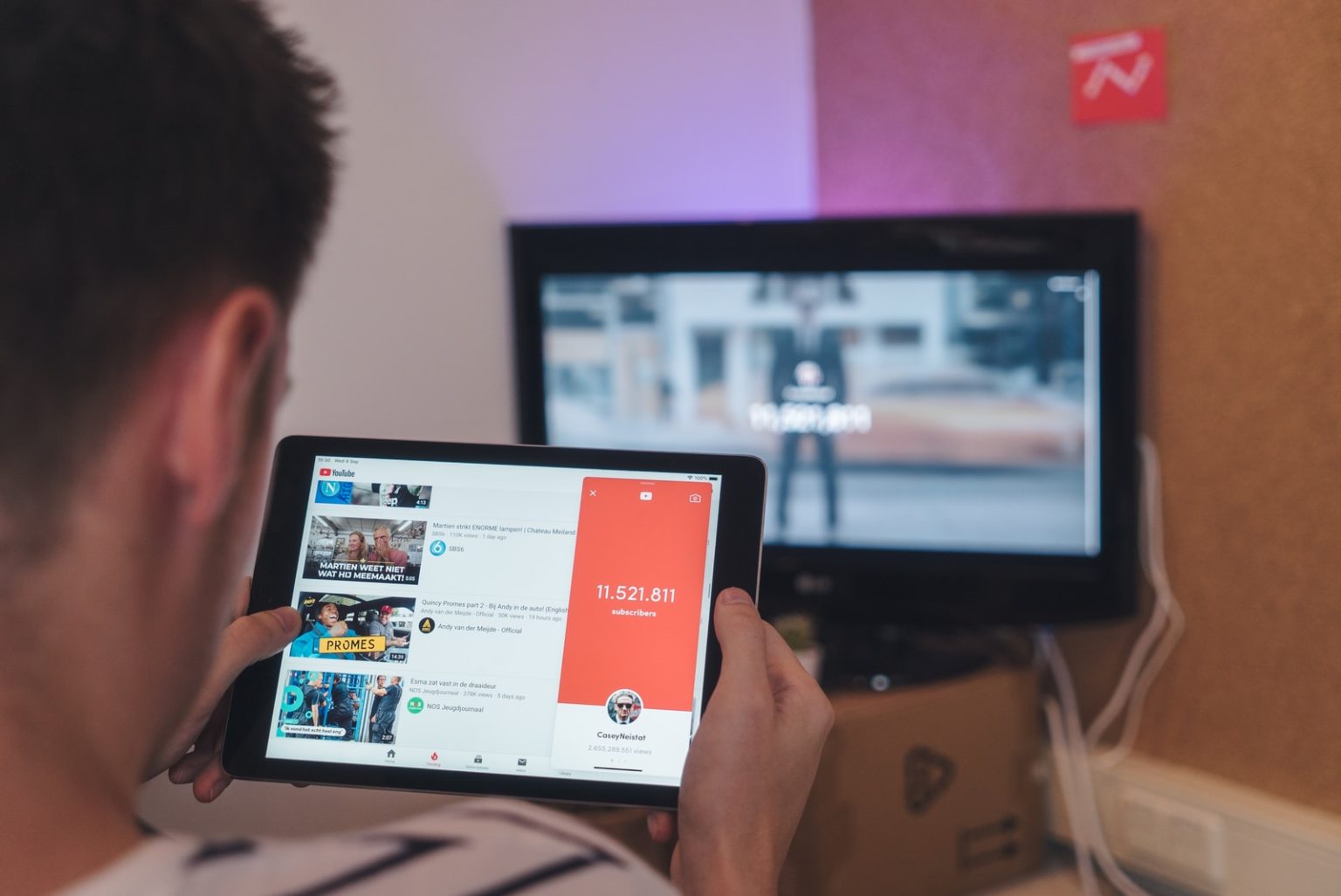 YouTube Thumbnail man browsing tablet sitting in front of TV