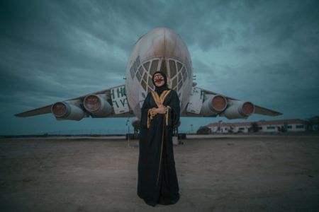 woman wearing black dress standing near white plane