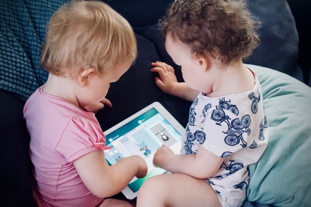What is learning? two toddlers sitting on sofa while using tablet computer